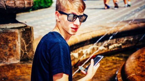 illustration: young man with sun glasses and smartphone in hand