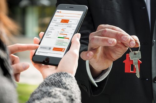 Person using mortgage application service on mobile telephone and person holding housekeys