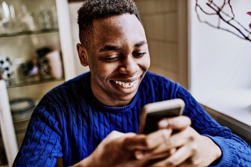 Smiling young man looking at smartphone